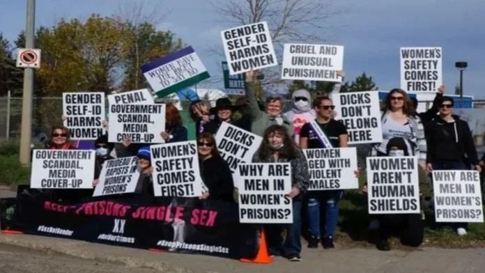 2021 protests against trans women aka men in women's prisons in Canada. Image description: a group of 20+ women and a few men hold signs saying things like "gender self-id harms women", "why are men in women's prisons" and "cruel and unusual punishment"
