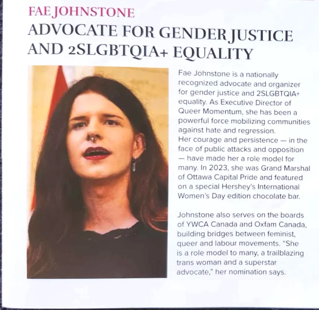 A photograph of a printed event program page. The heading in pink text reads "FAE JOHNSTONE," followed by a bold black headline: "ADVOCATE FOR GENDER JUSTICE AND 2SLGBTQIA+ EQUALITY." On the left is a photo of a man with long, straight dark reddish hair, a septum piercing, dark lipstick, and dangling earrings, photographed indoors with a partially visible flag behind them. His adam's apple is clearly visible. The body text to the right reads: "Fae Johnstone is a nationally recognized advocate and organizer for gender justice and 2SLGBTQIA+ equality. As Executive Director of Queer Momentum, she has been a powerful force mobilizing communities against hate and regression. Her courage and persistence — in the face of public attacks and opposition — have made her a role model for many. In 2023, she was Grand Marshal of Ottawa Capital Pride and featured on a special Hershey's International Women's Day edition chocolate bar. Johnstone also serves on the boards of YWCA Canada and Oxfam Canada, building bridges between feminist, queer and labour movements. 'She is a role model to many, a trailblazing trans woman and a superstar advocate,' her nomination says."
Note: despite Fae being a man who says his pronouns are she/they, the program exclusively uses female pronouns for him.
