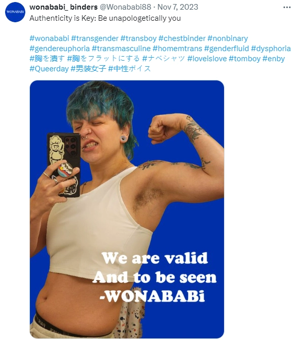 Burn your binders, Girls! Wonababi ad of a teenaged girl with short blue hair wearing a binder, flexing her arm and taking a selfie